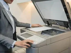 Female manager using office copier with precision and focus.