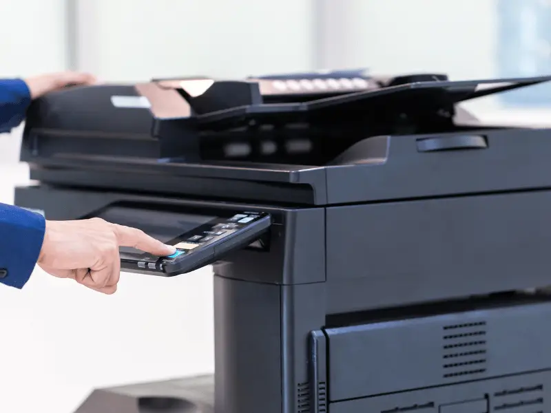 Office professional operating photocopier controls in the office