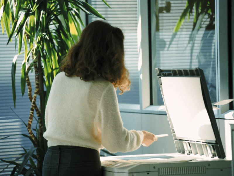Woman operating a photocopier in an office setting