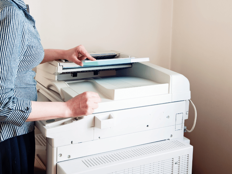 Female employee pressing buttons on a photocopier